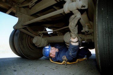 ODOT employee inspecting the under carriage of a truck