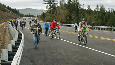 Photo of a group of people riding bicycles along a highway