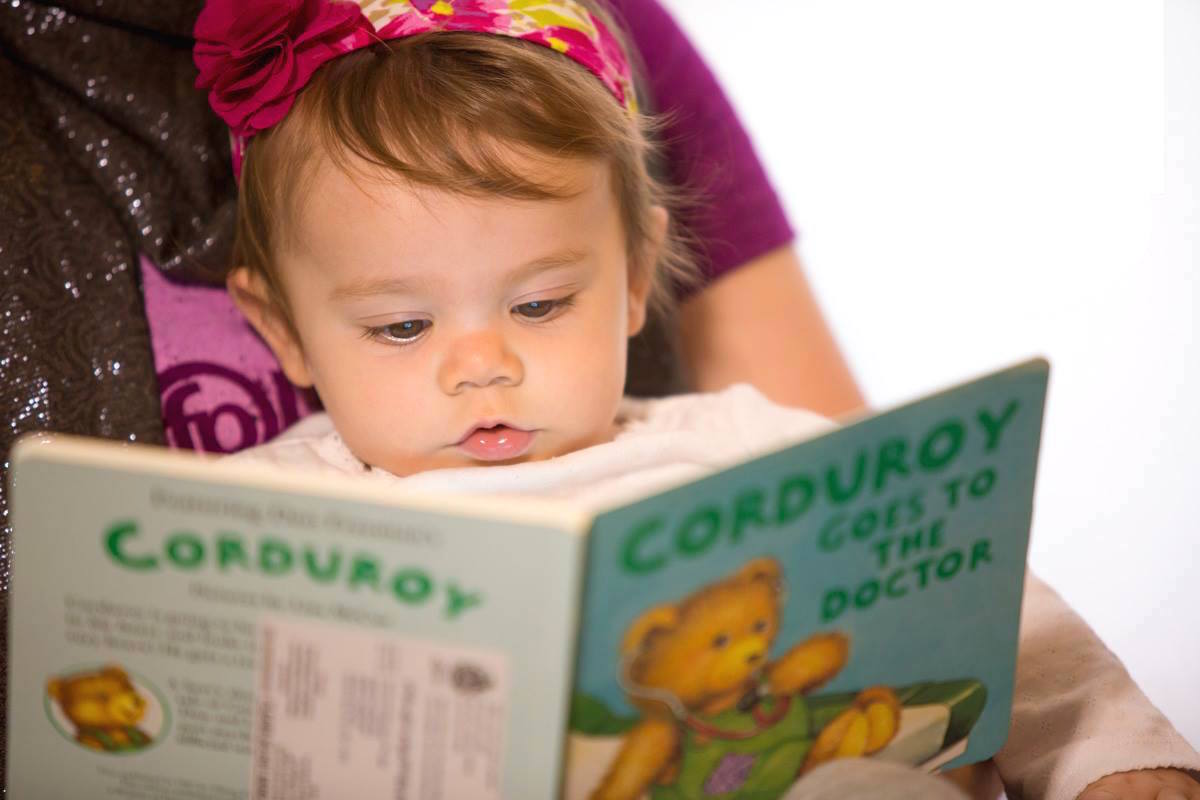 young baby girl being read to