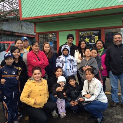 A group of community members gathered for a photo op in front of a local business.