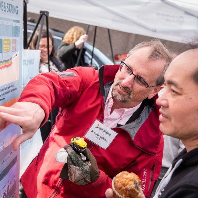 Two men examine an informational poster.