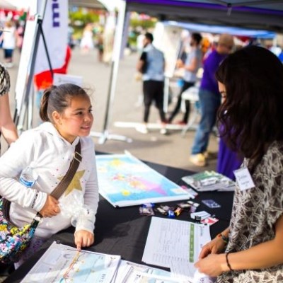 A young girl speaks with an ODOT worker at an information booth.