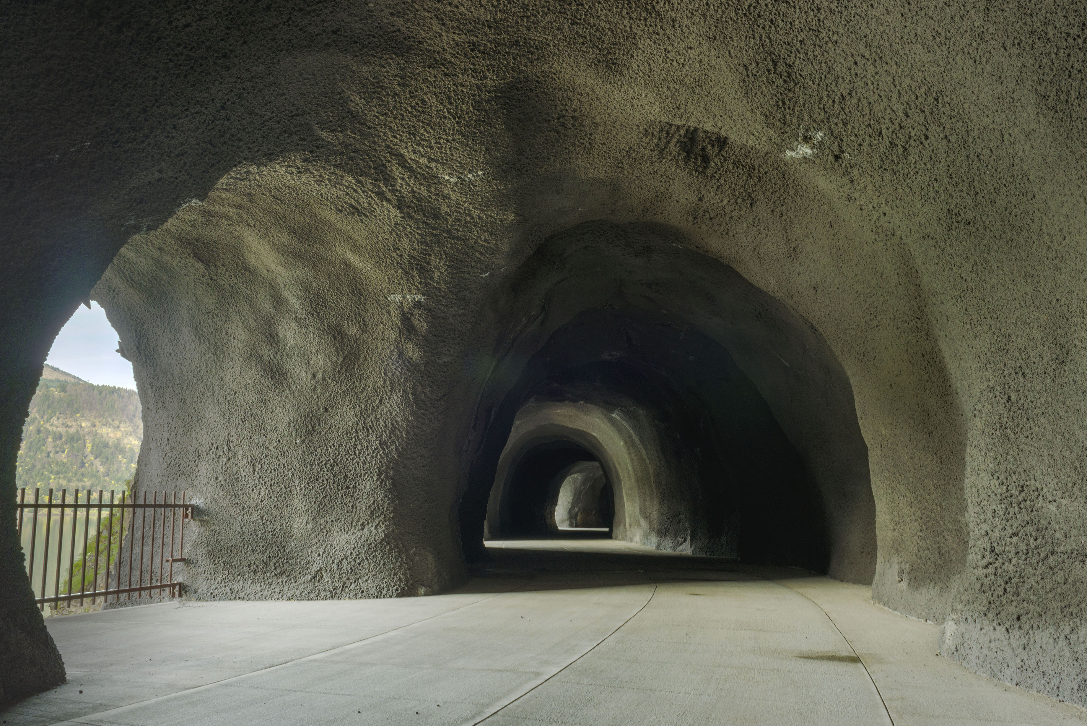 Standing in the large, arched concrete tunnel with windows letting in sunlight and views