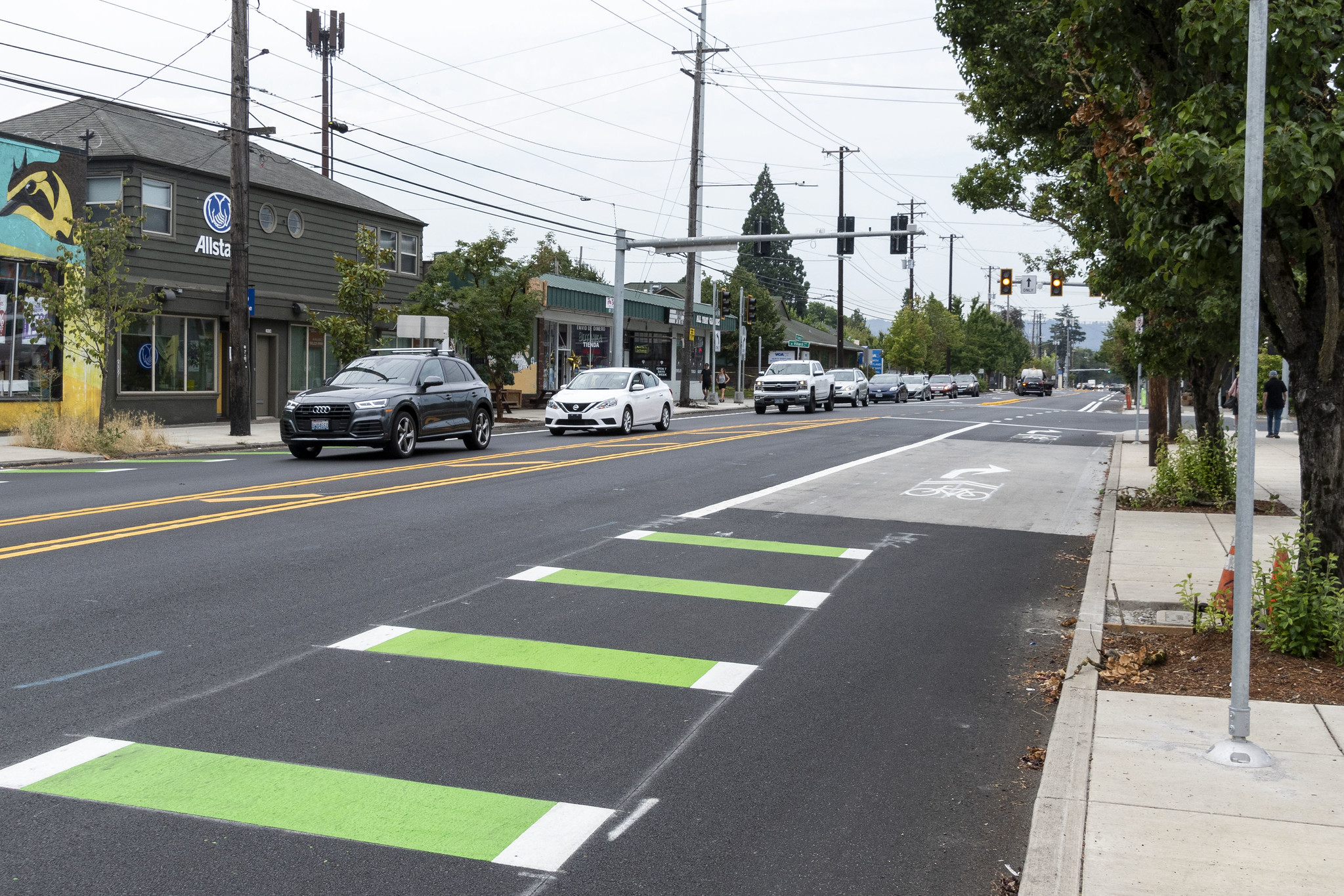 Photo of a local road with a green and white striped bike lane and right hand turn arrows. 