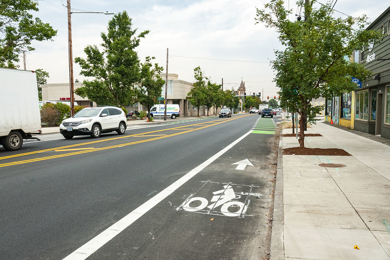 Photo of a local road with a bike lane that transistions to green and white stripes.