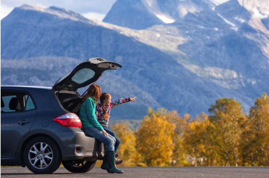 Two people sitting on the back of a car