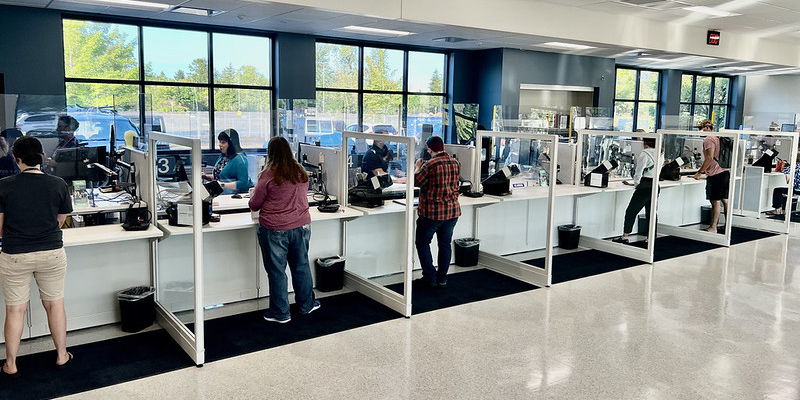 Customers stand at the counter at DMV