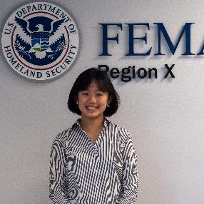 Person standing in front of a wall with a FEMA Region 10 logo