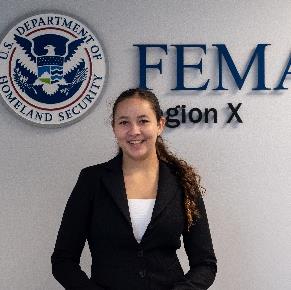 Person standing in front of a wall with a FEMA Region 10 logo