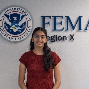 Person standing in front of a wall with a FEMA Region 10 logo